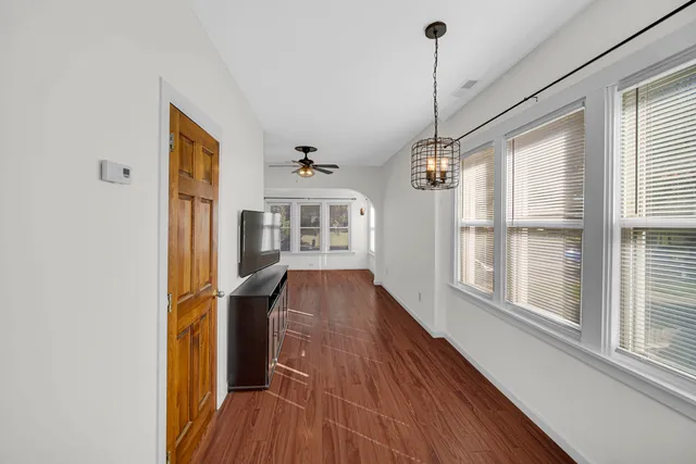a view of hallway with windows and wooden floor
