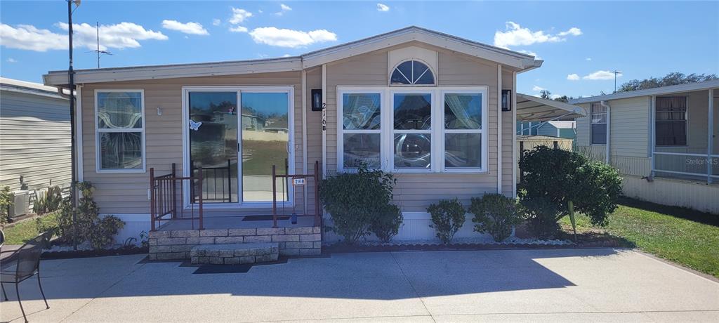 4421 Lane Road, Unit 216B Zephyrhills, FL 33541 - Photo 2 of 22 a front view of a house with garden