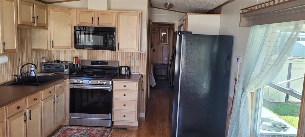 4421 Lane Road, Unit 216B Zephyrhills, FL 33541 - Photo 7 of 22 a kitchen with stainless steel appliances a refrigerator stove and sink