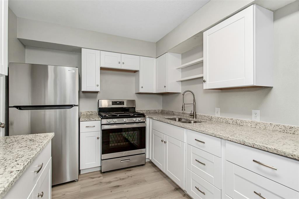 4916 Worth Street, Unit 1 Dallas, TX 75214 - Photo 11 of 27 a kitchen with granite countertop a sink stove and refrigerator