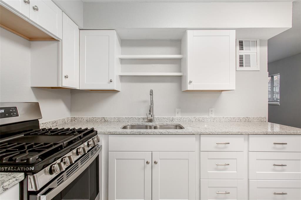 4916 Worth Street, Unit 1 Dallas, TX 75214 - Photo 12 of 27 a kitchen with granite countertop white cabinets and stainless steel appliances
