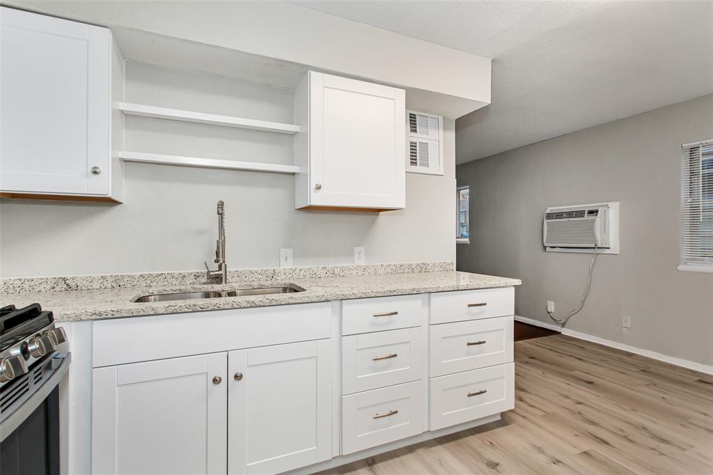 4916 Worth Street, Unit 1 Dallas, TX 75214 - Photo 13 of 27 a kitchen with granite countertop a sink cabinets and stainless steel appliances