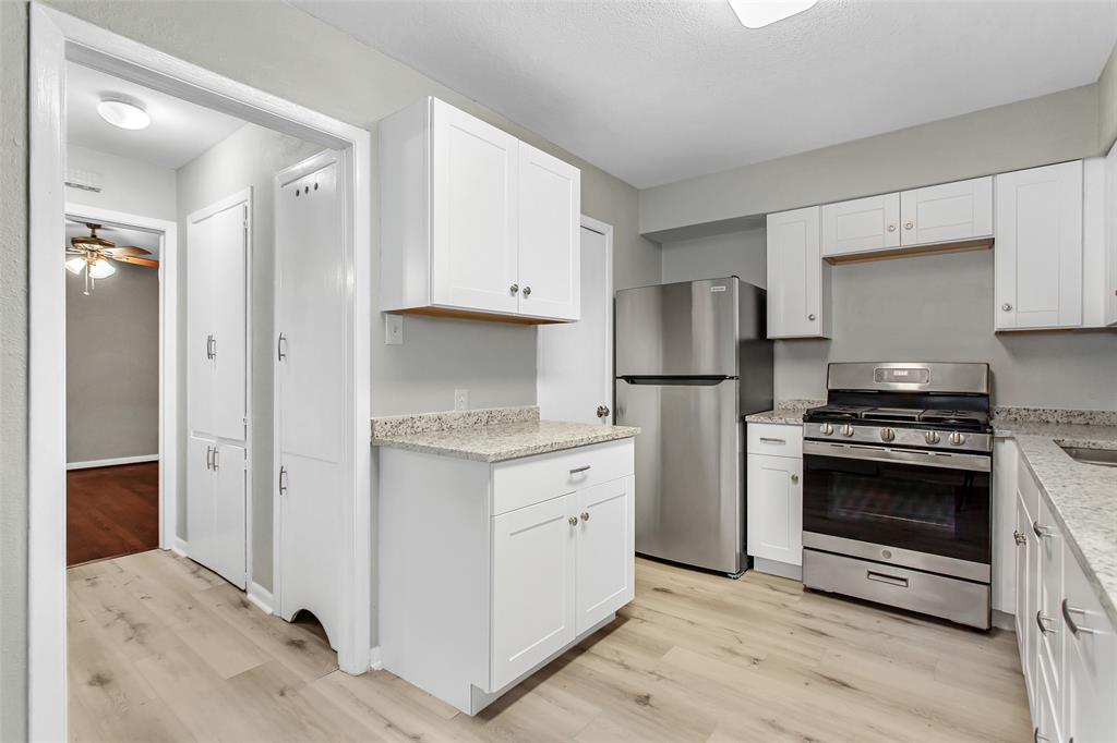 4916 Worth Street, Unit 1 Dallas, TX 75214 - Photo 14 of 27 a kitchen with white cabinets and stainless steel appliances
