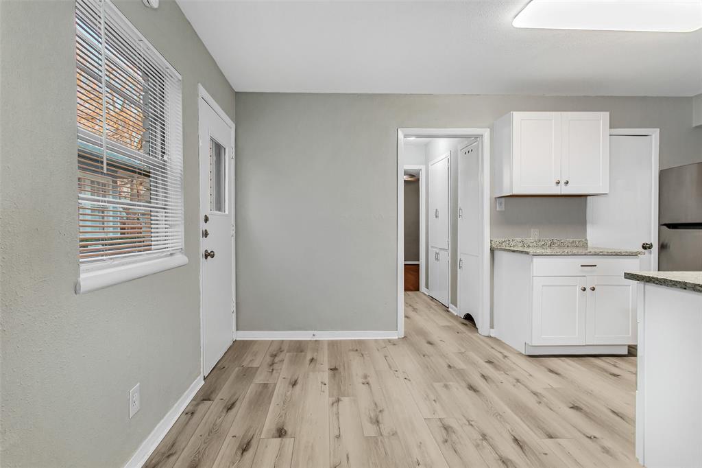 4916 Worth Street, Unit 1 Dallas, TX 75214 - Photo 9 of 27 a kitchen with granite countertop white cabinets and wooden floor
