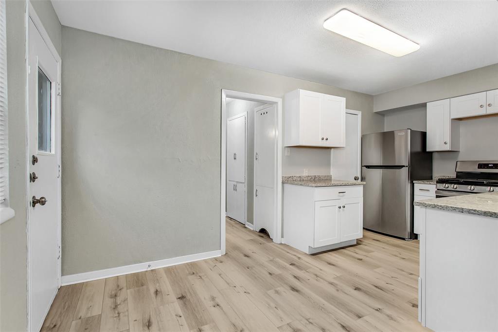4916 Worth Street, Unit 1 Dallas, TX 75214 - Photo 10 of 27 a kitchen with white cabinets and stainless steel appliances