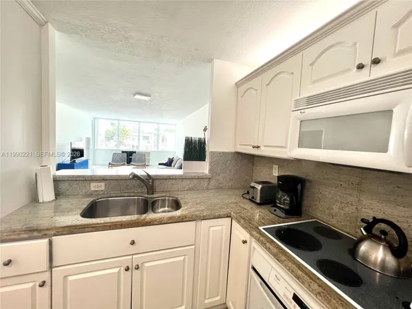 a kitchen with granite countertop a sink and cabinets