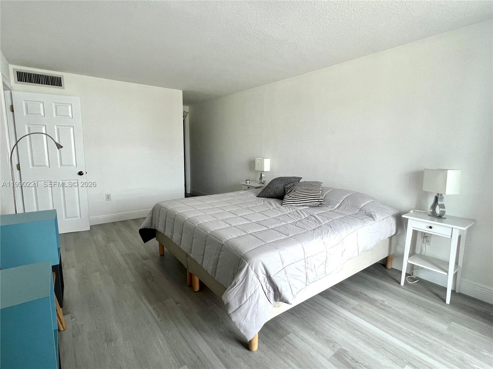 8233 Harding Avenue, Unit 204 Miami Beach, FL 33141 - Photo 17 of 18 a bedroom with a bed and wooden floor