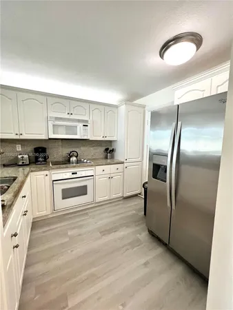 a kitchen with cabinets stainless steel appliances and a counter top space