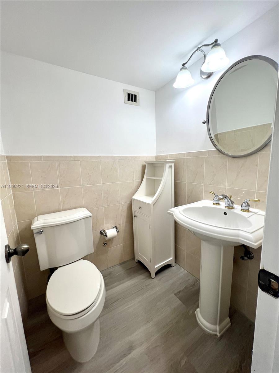 8233 Harding Avenue, Unit 204 Miami Beach, FL 33141 - Photo 4 of 18 a bathroom with a sink mirror and toilet
