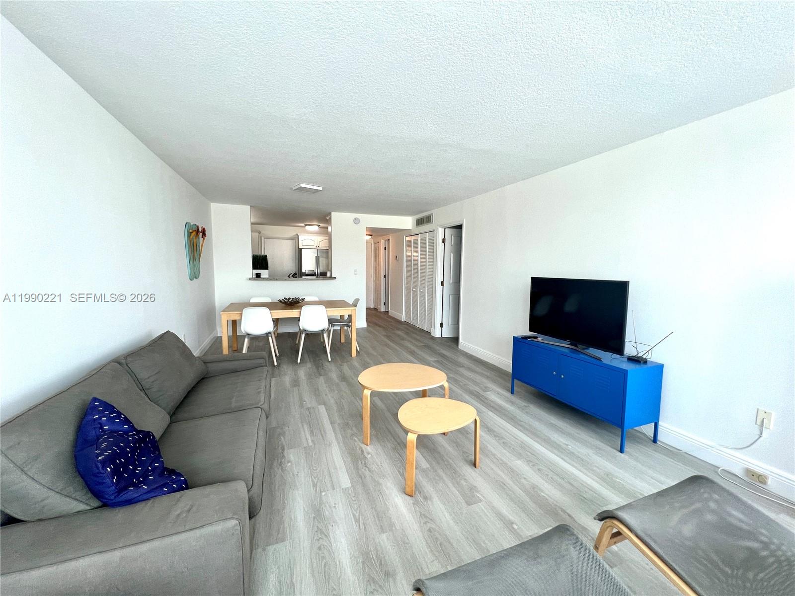 8233 Harding Avenue, Unit 204 Miami Beach, FL 33141 - Photo 5 of 18 a living room with furniture and a flat screen tv