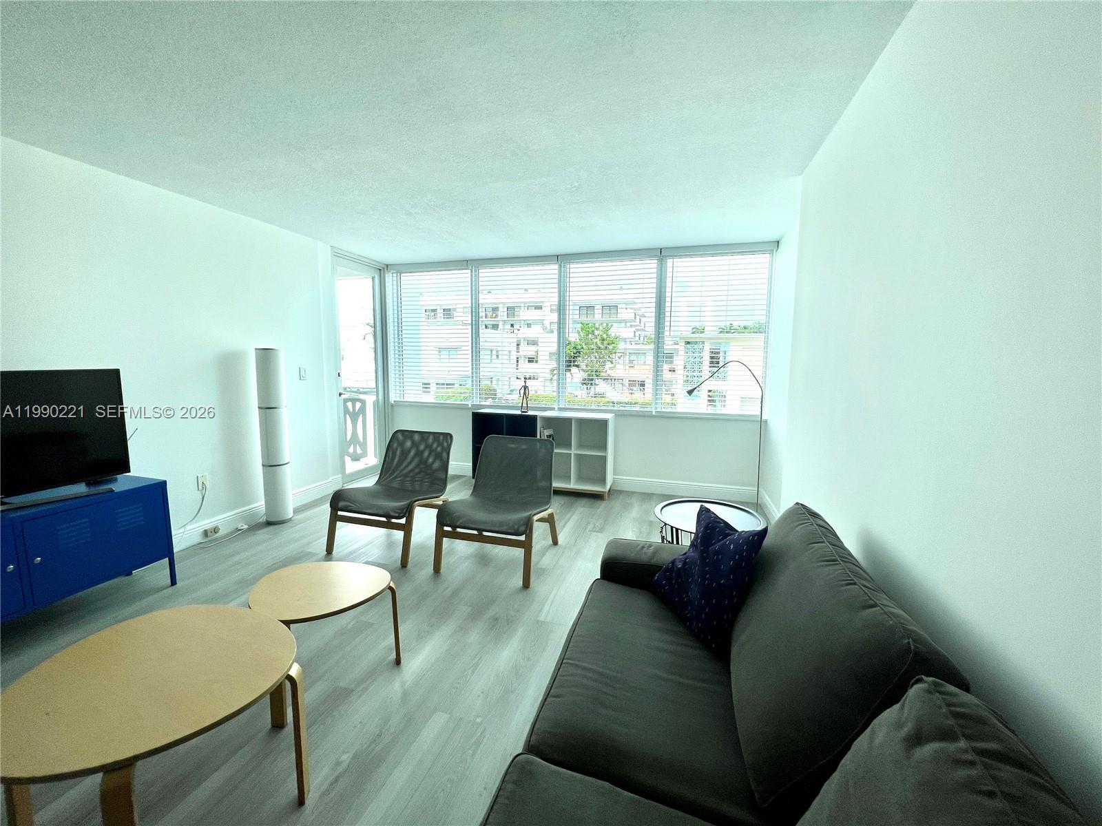 8233 Harding Avenue, Unit 204 Miami Beach, FL 33141 - Photo 9 of 18 a living room with furniture and a flat screen tv