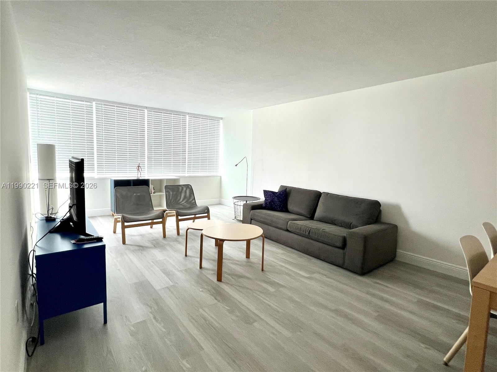 8233 Harding Avenue, Unit 204 Miami Beach, FL 33141 - Photo 10 of 18 a living room with furniture and a flat screen tv