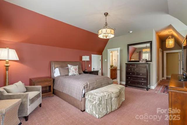 a spacious bedroom with a bed dresser and a flat screen tv