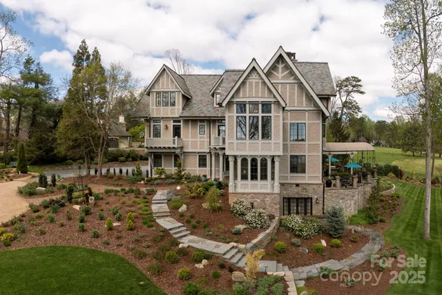 a view of residential houses with yard and lake view in back