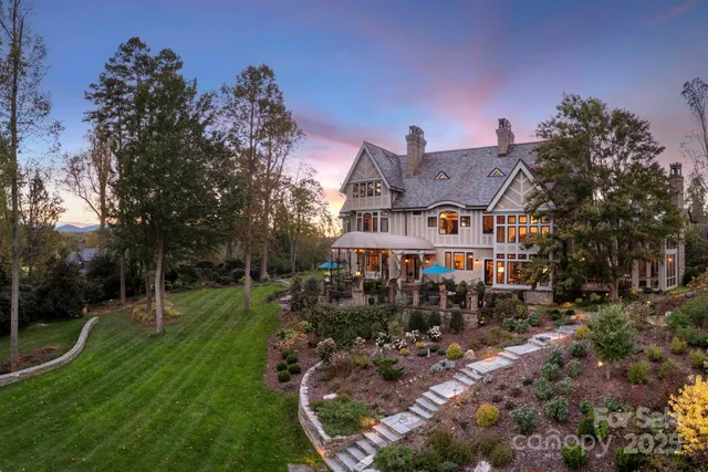 a view of a house with a big yard and large trees