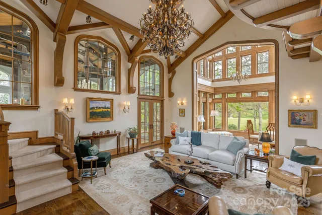 a living room with furniture a fireplace and large windows