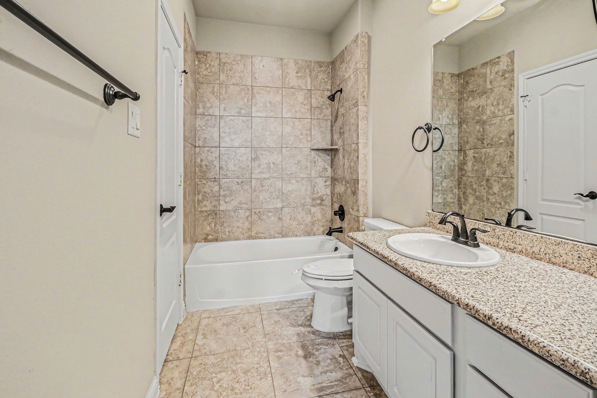 3310 Ralston Edge Lane Houston, TX 77059 - Photo 45 of 50 a bathroom with a granite countertop sink a toilet a mirror a bathtub and shower