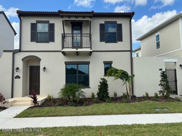a view of a white house with large windows and a yard