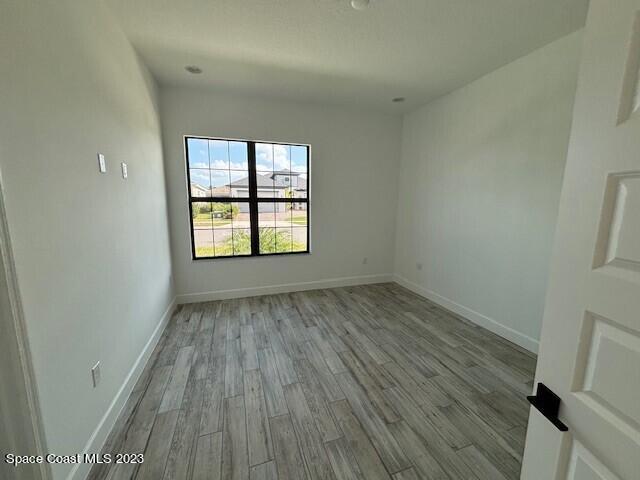 8326 Lyside Drive Melbourne, FL 32940 - Photo 8 of 17 an empty room with wooden floor and windows