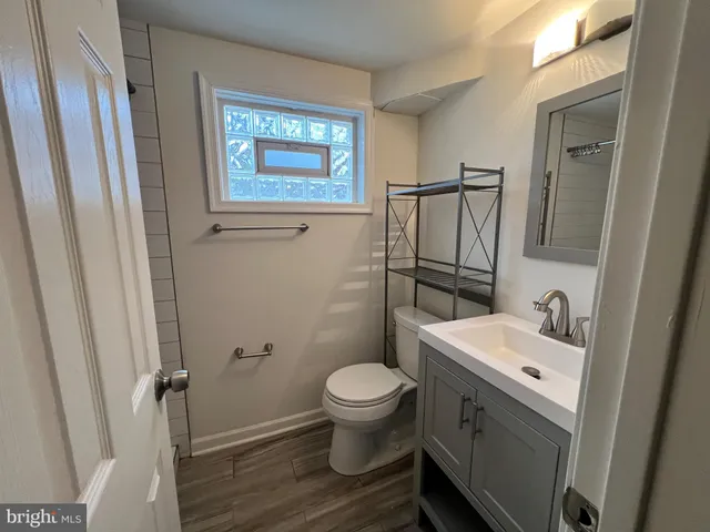 a bathroom with a granite countertop toilet sink and a mirror