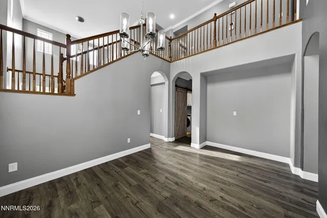 a open kitchen with stainless steel appliances granite countertop a refrigerator a sink dishwasher a stove and a dining table with wooden floor