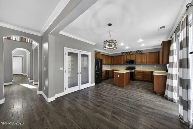 a kitchen with stainless steel appliances granite countertop a stove a sink dishwasher a refrigerator and cabinets with wooden floor