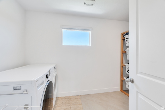 646 South Meade Street Mapleton, UT 84664 - Photo 20 of 46 Dedicated laundry area featuring a front-loading washer and dryer, light-toned flooring, and a window providing natural illumination