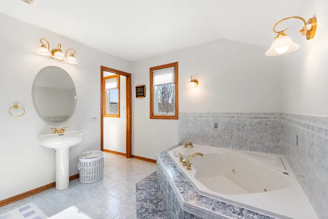 a bathroom with a tub sink and mirror