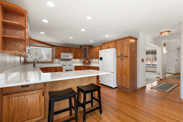 a kitchen with stainless steel appliances a dining table chairs and refrigerator
