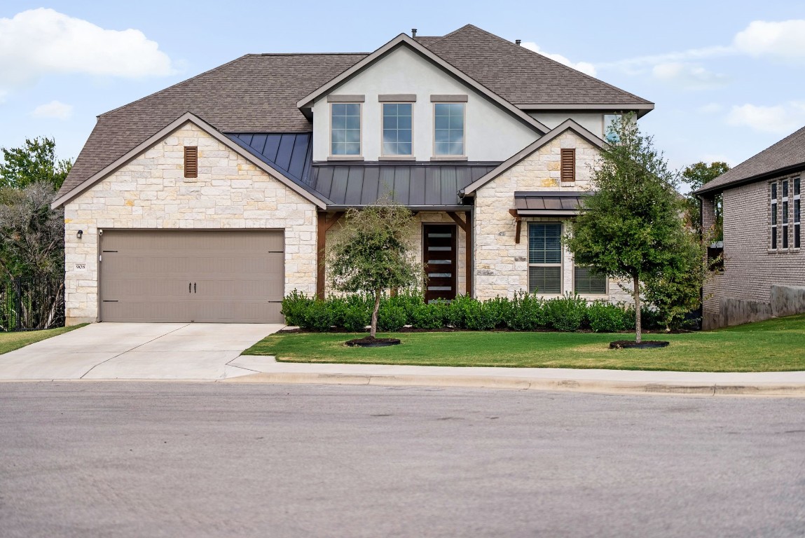 a front view of a house with a yard and garage