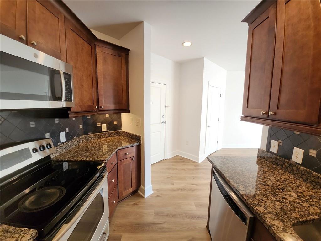 325 East Paces Ferry Road Northeast, Unit 1409 Atlanta, GA 30305 - Photo 4 of 14 a kitchen with stainless steel appliances granite countertop a sink stove and cabinets