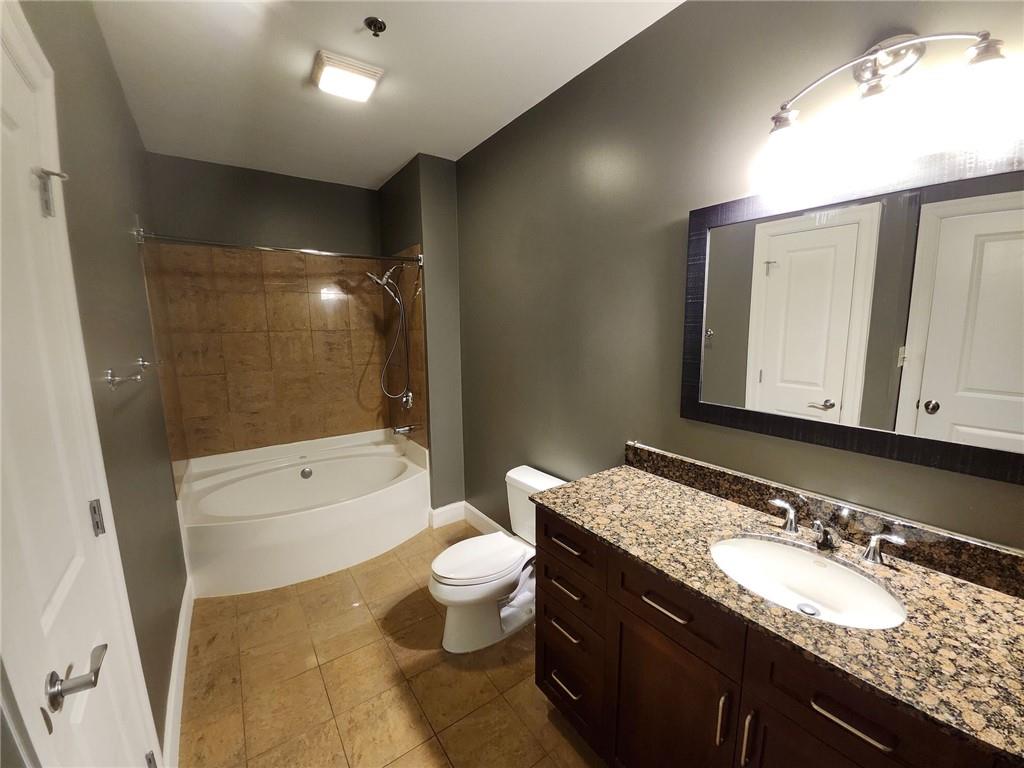 325 East Paces Ferry Road Northeast, Unit 1409 Atlanta, GA 30305 - Photo 7 of 14 a bathroom with a granite countertop sink a toilet a mirror and bathtub
