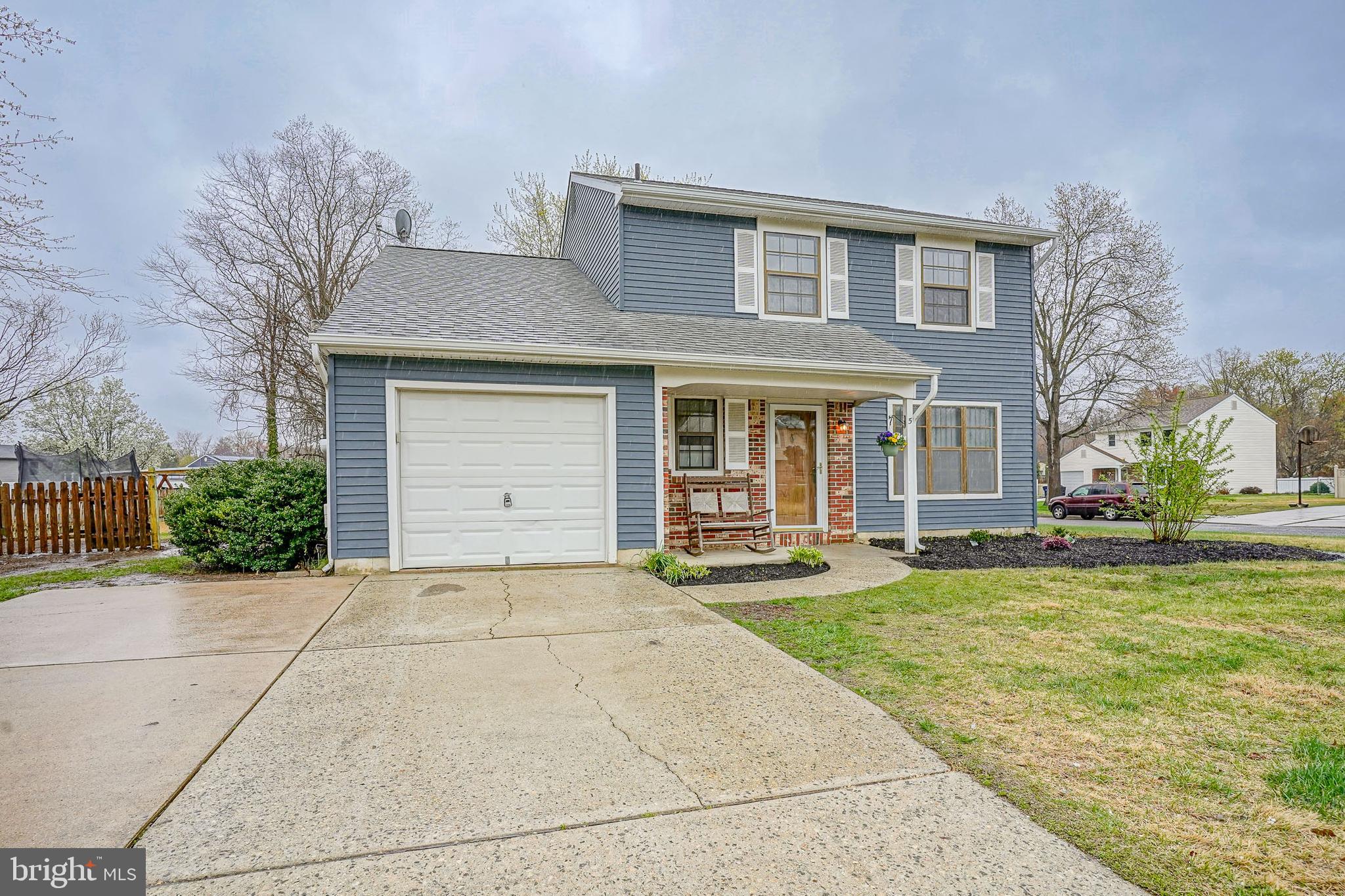 a front view of a house with a garden and trees