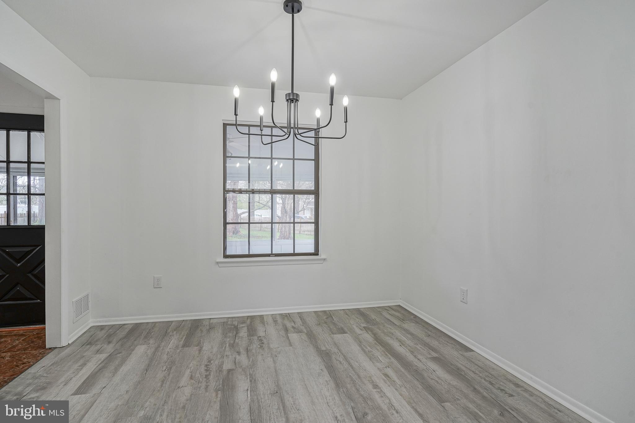 5 Wickham Lane Westampton, NJ 08060 - Photo 8 of 32 an empty room with wooden floor exposed radiator and windows