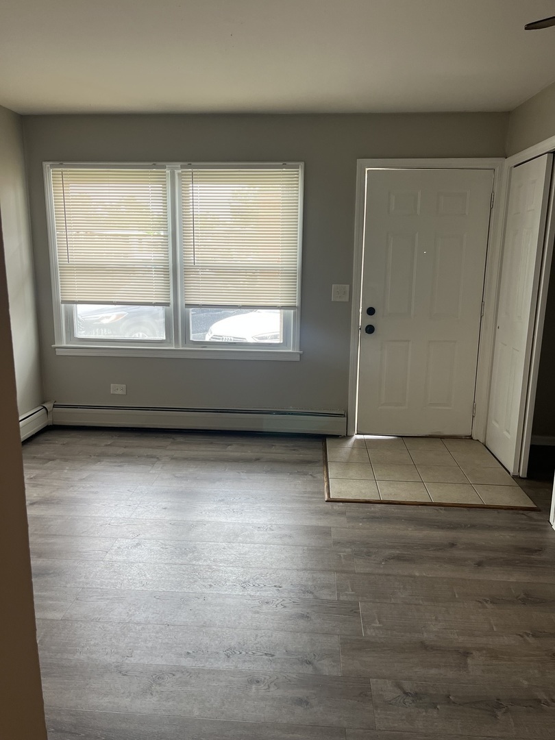 1340 North Main Street, Unit A7 Wheaton, IL 60187 - Photo 2 of 7 an empty room with wooden floor and windows