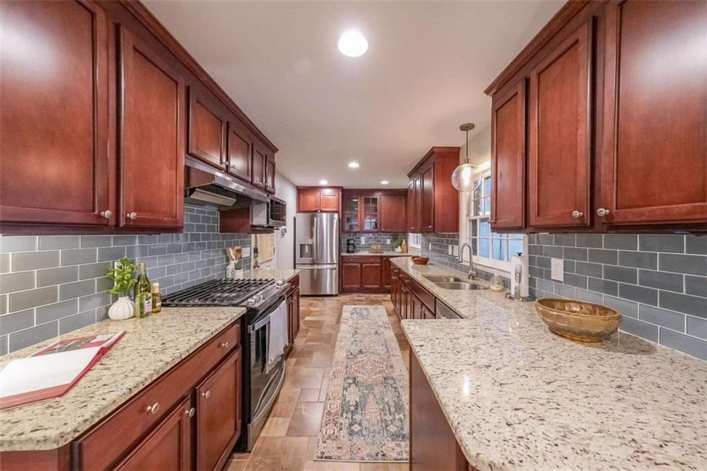 1445 Linkwood Lane Decatur, GA 30033 - Photo 8 of 30 a kitchen with stainless steel appliances granite countertop wooden cabinets a stove and a sink