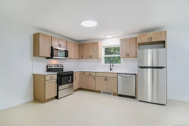 a kitchen with white cabinets and stainless steel appliances