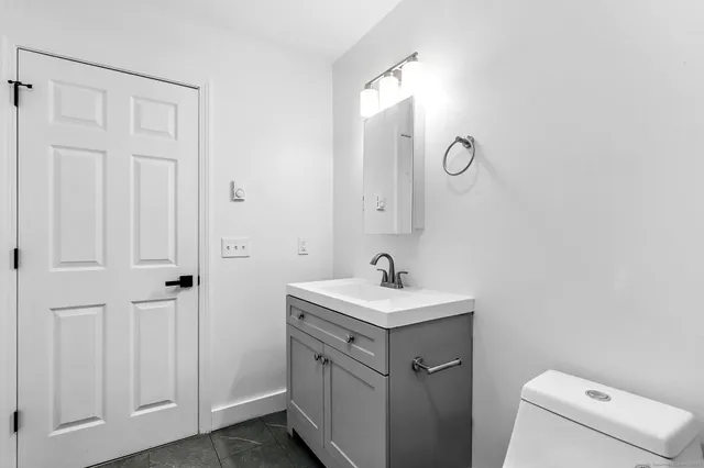 a bathroom with a sink a toilet and a mirror