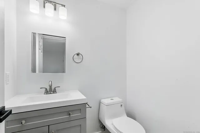 a bathroom with a toilet a sink and mirror