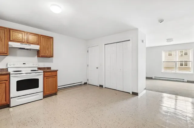 an empty room with a kitchen and a sink