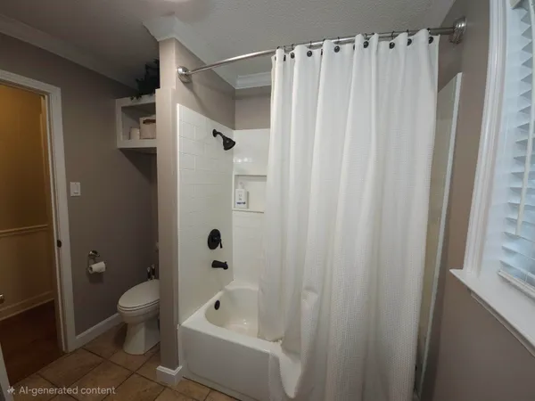 a bathroom with a shower curtain a toilet a sink and a shower