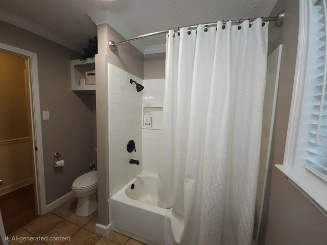 a bathroom with a shower curtain a toilet a sink and a shower