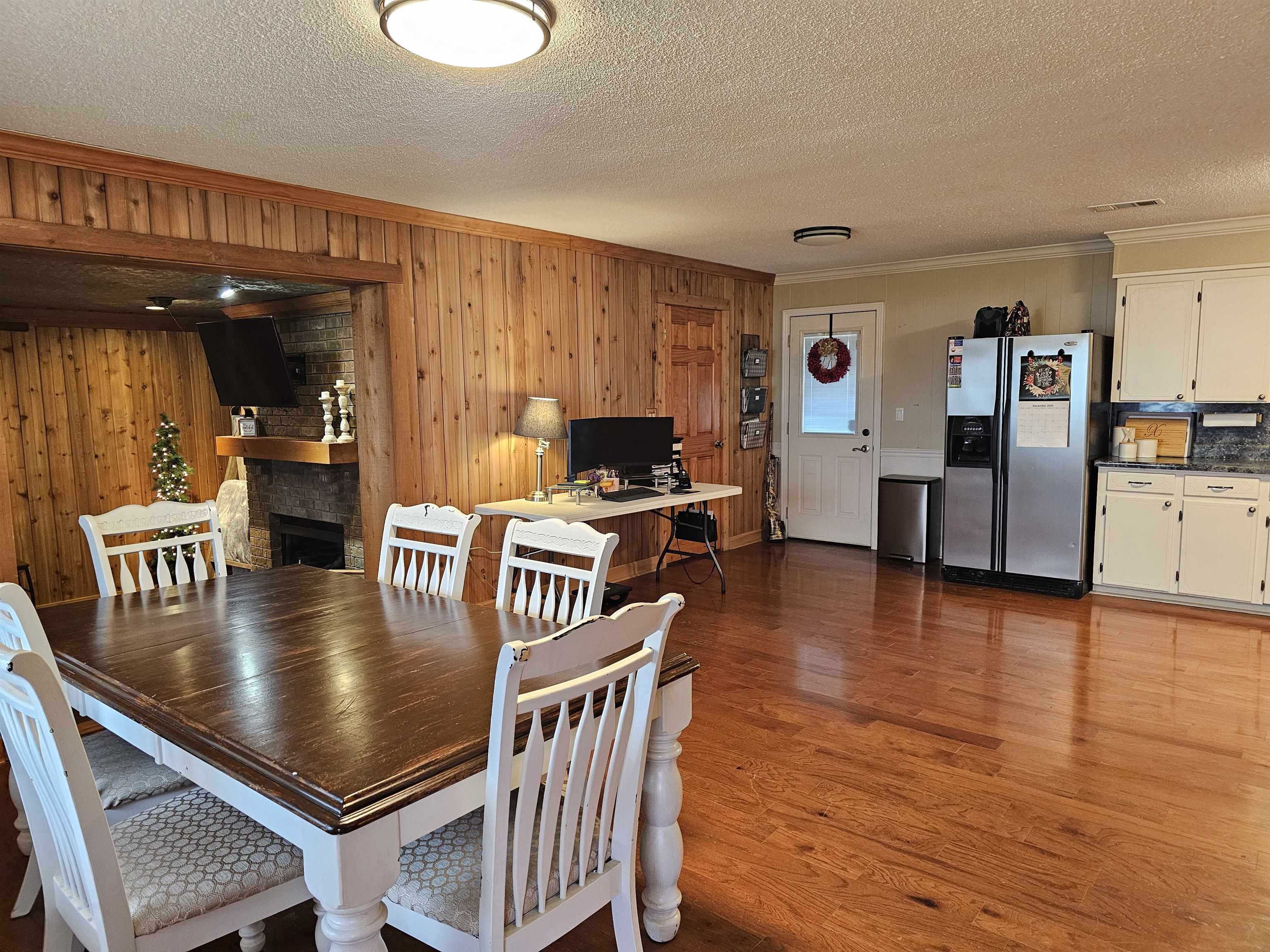 3920 Antioch Highway 51 Road Covington, TN 38019 - Photo 5 of 25 a kitchen with stainless steel appliances granite countertop a stove top oven a sink a dining table and chairs with wooden floor