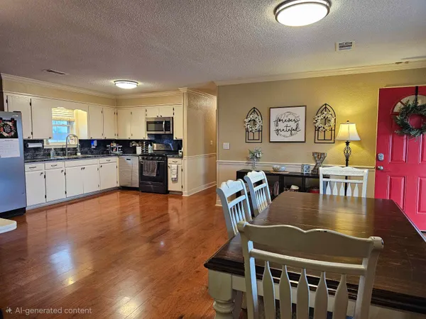 a kitchen with stainless steel appliances granite countertop a stove a refrigerator a dining table and chairs with wooden floor