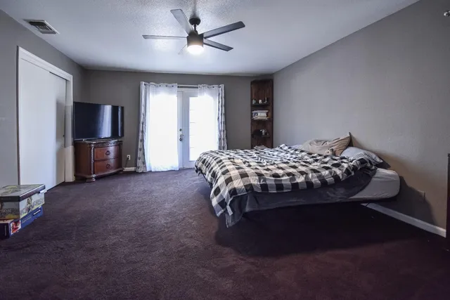 a bed sitting in a spacious bedroom next to a window