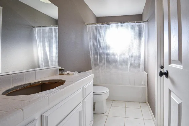 a bathroom with a sink a toilet a mirror and shower