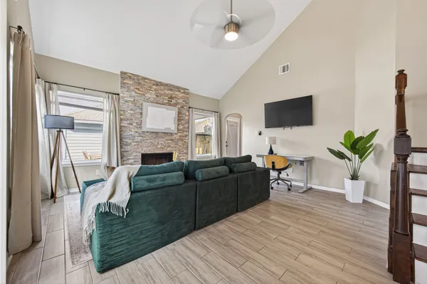 a living room with furniture a flat screen tv and a fireplace