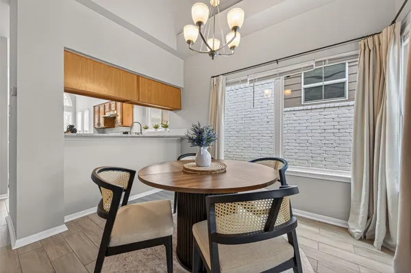 a view of a dining room with furniture a chandelier and wooden floor