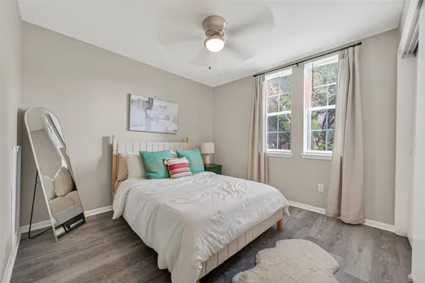 a bedroom with a bed wooden floor and a window
