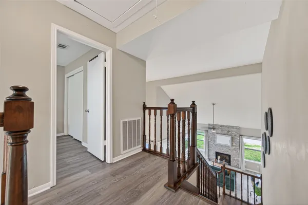 a view of a hallway with wooden floor and entryway